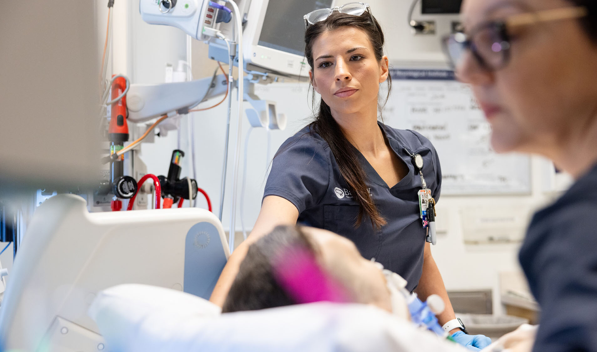 a barrow neuroscience nurse delivering bedside care to a patient in the neurocritical care unit
